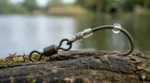 Close-up of a specialist carp hook attached to a spinner swivel, the foundation of a Ronnie rig setup.
