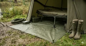 An illustration highlighting the clip-in heavy-duty PVC groundsheet of a modern fishing brolly system to prevent dampness.
