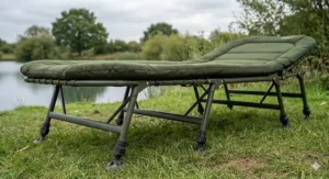 A modern carp fishing bedchair sleep system featuring an integrated five-season sleeping bag zipped to the frame inside a bivvy.