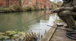 Angler fishing a UK canal margin using a light lure rod with a micro jig weight.
