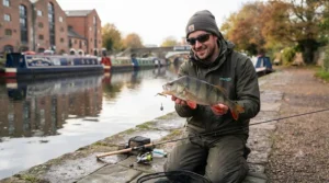 Angler holding a fine perch caught using a drop shot rig on a UK canal, demonstrating successful ultra-light lure fishing tactics.