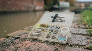 Open tackle box organised with small snap links, fluorocarbon leader, and micro lures for a roving canal session.