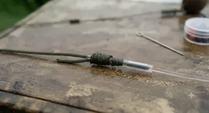 Close-up of a neatly tied knot joining heavy monofilament mainline to a braided hooklink for British river monster fishing.