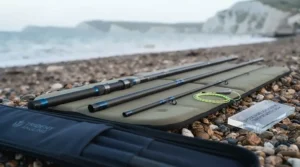 A dismantled three-piece travel beachcaster rod shown alongside its protective case.